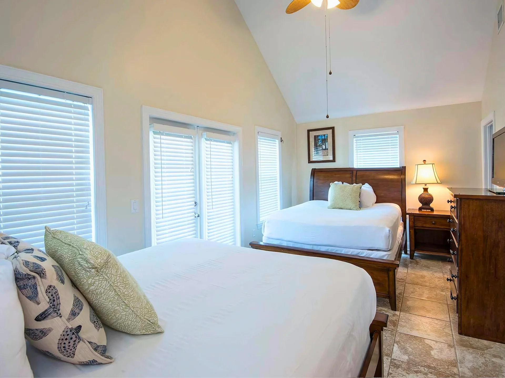Cozy double bedroom with white linens, wood furniture, and natural light at Hawks Cay Resort.