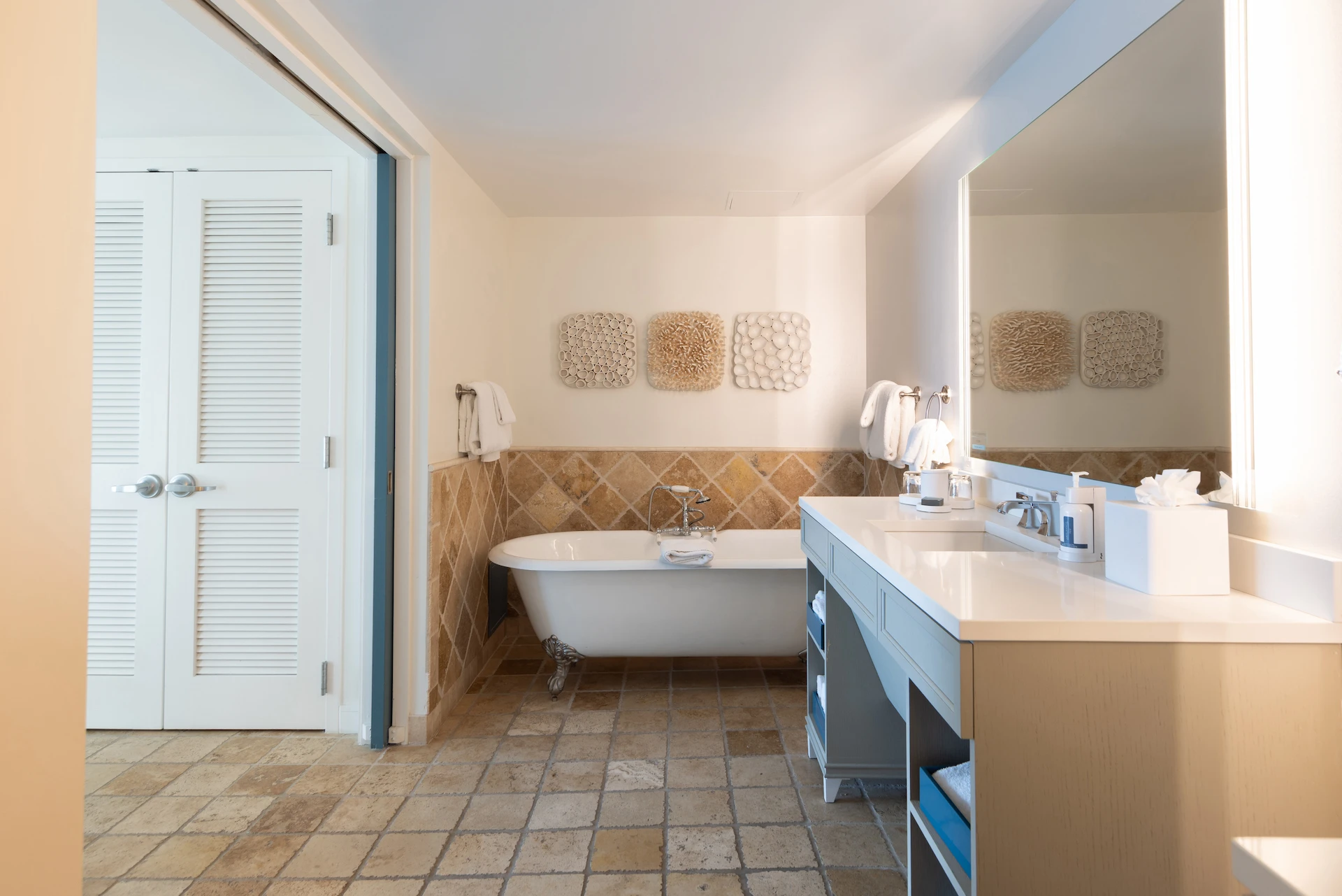 Stylish bathroom with clawfoot tub, diamond tile wall, and spacious vanity with mirror.