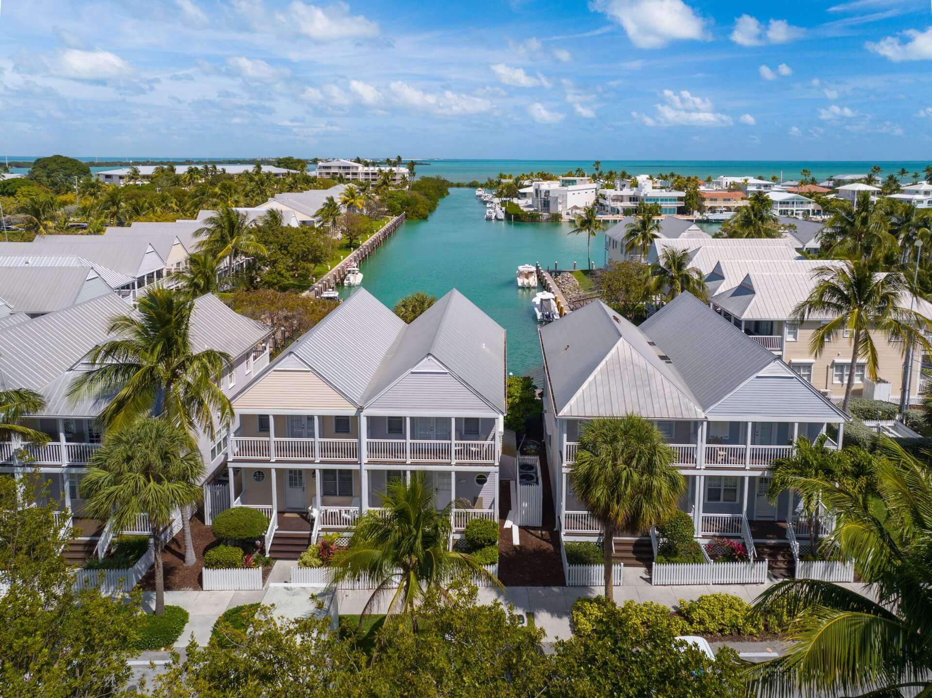 Charming coastal cottages line a tranquil canal, just steps from turquoise waters and island living at its finest.