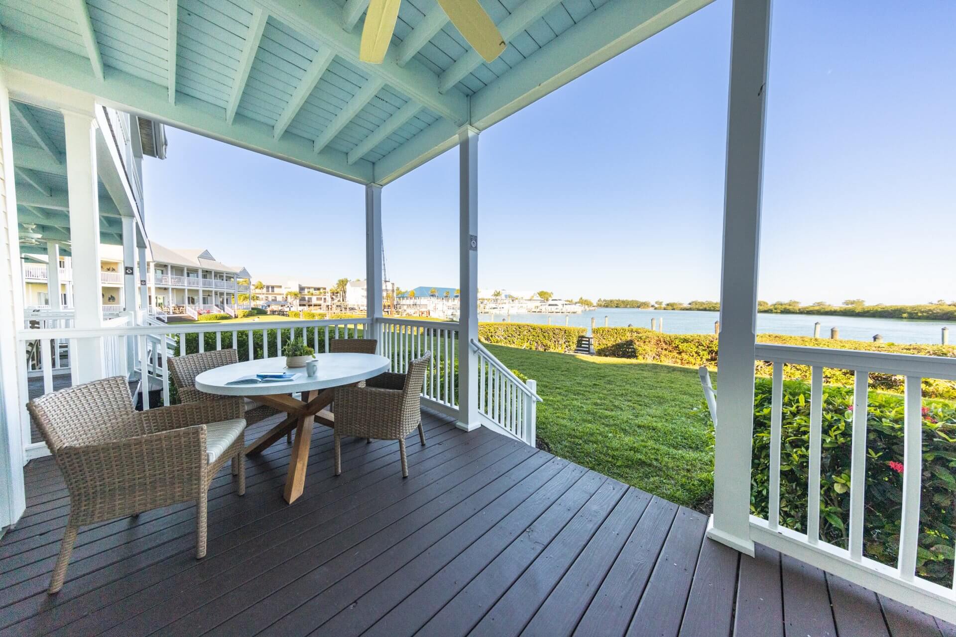 Covered waterfront porch with cozy seating, marina views, and a breezy coastal retreat feel.